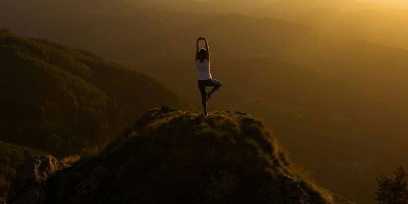 En kvinna utöver Yoga på en klippa.